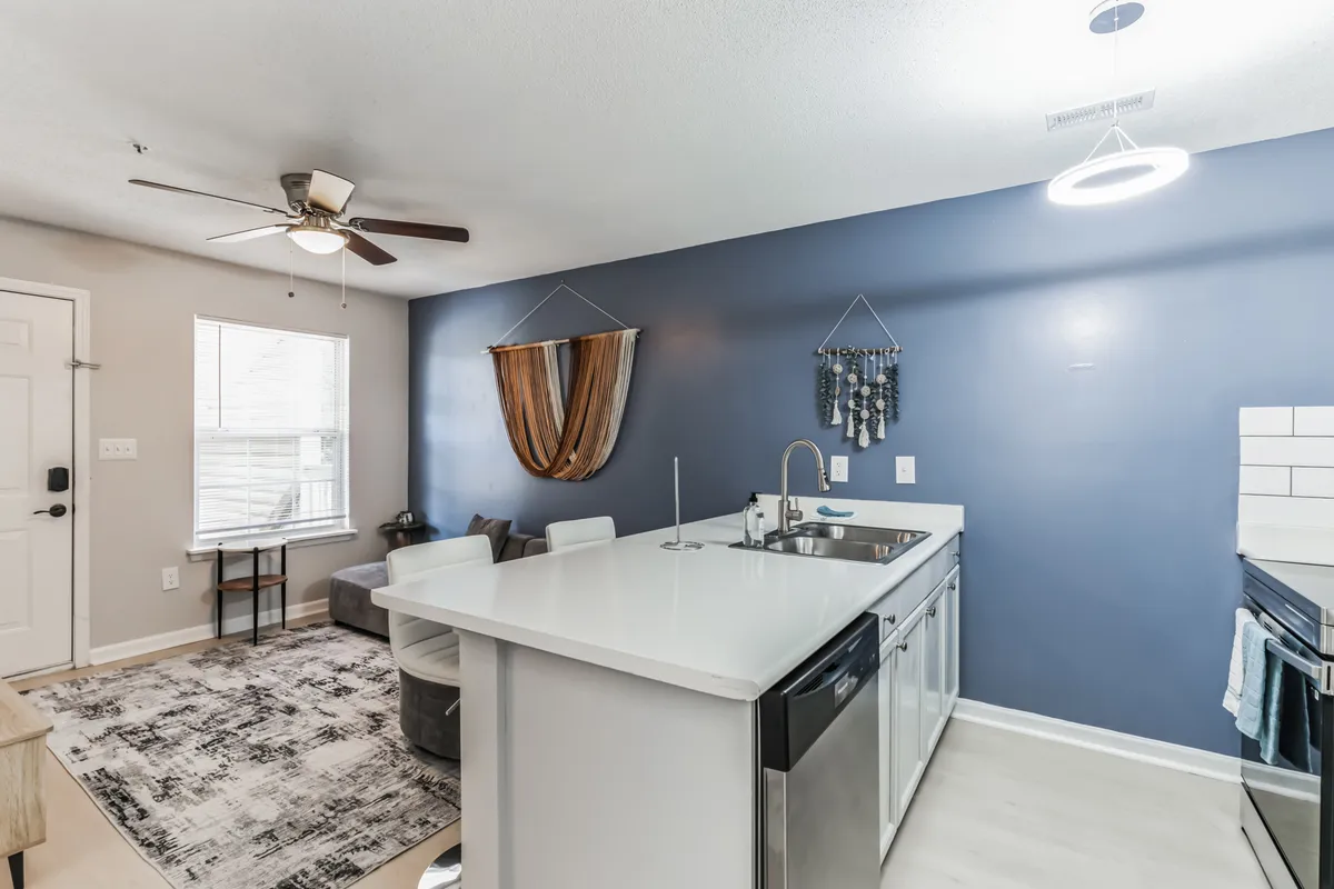 An inviting open-concept kitchen with a central island, plush seating nearby, and tasteful decorative accents. The layout connects the cooking area with a cozy dining or socializing space, emphasizing comfort and versatility.
